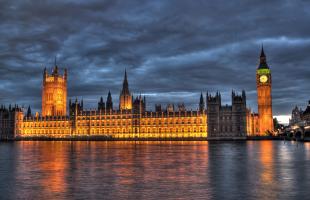 Photograph of the Palace of Westminster at dusk, taken from the south bank of the River Thames.